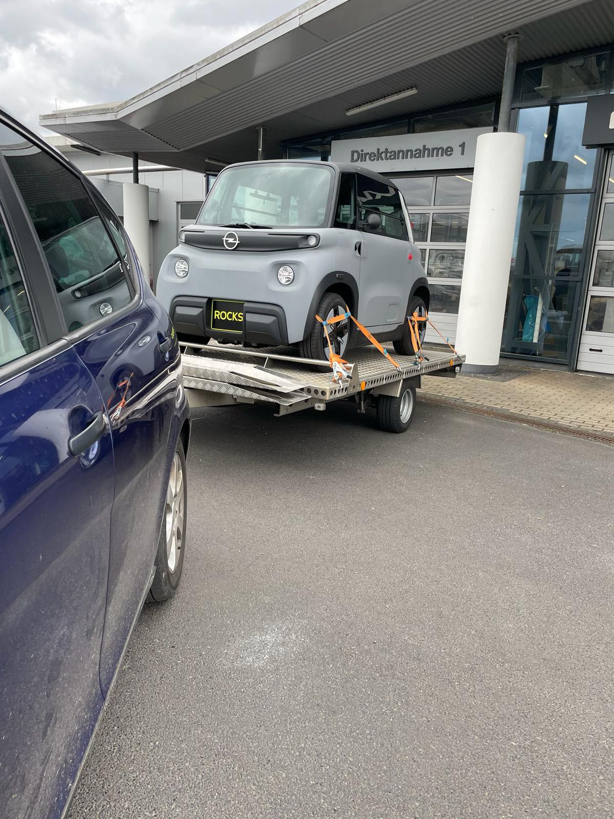 Kleinwagen auf dem Transportanhänger von Santos Transport gesichert – Auto-Abholung beim Händler